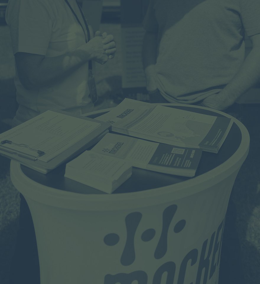 Informational table with brochures and paperwork at an outdoor event